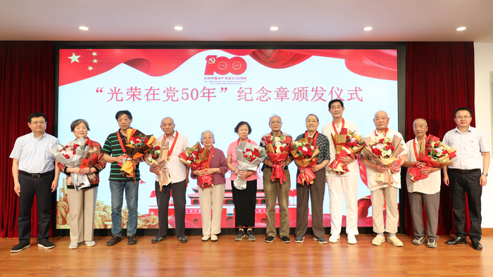 校領導為退休黨員頒發紀念章、獻花並合影留念